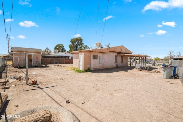 rear view of property featuring a patio, fence, and stucco siding