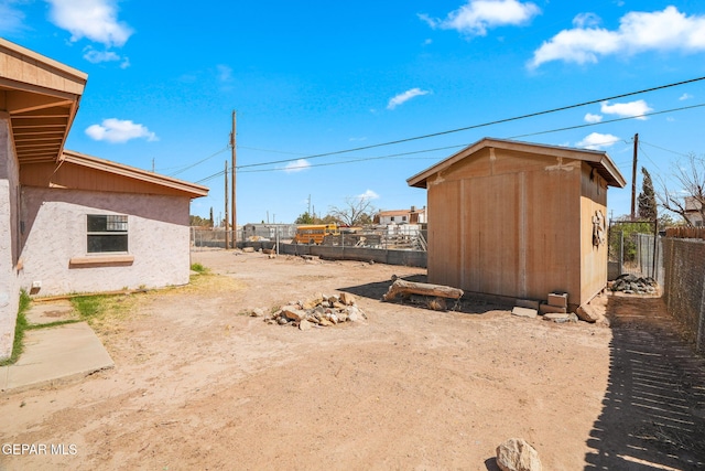 view of yard featuring an outdoor structure, a fenced backyard, and a storage shed