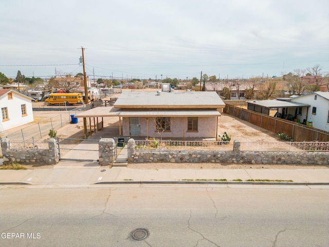 view of front facade featuring a fenced front yard, concrete driveway, and a gate