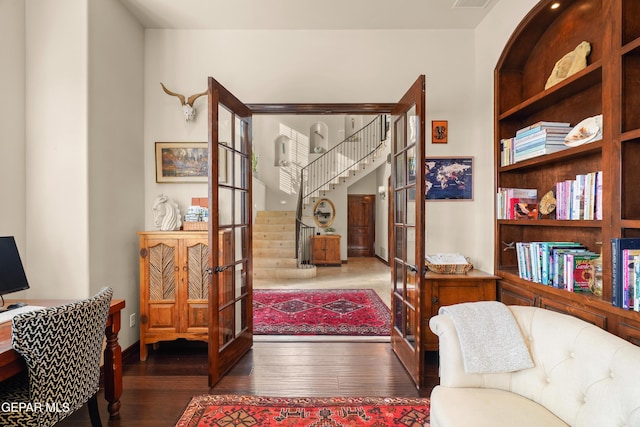 living area featuring french doors, visible vents, hardwood / wood-style floors, and stairway