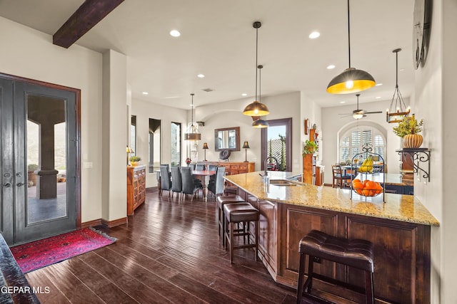 bar with dark wood-type flooring, pendant lighting, recessed lighting, and a sink