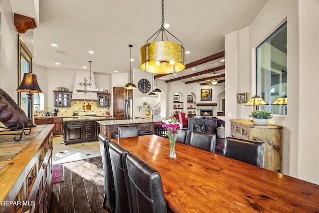 dining space with visible vents, a ceiling fan, wood finished floors, recessed lighting, and a lit fireplace
