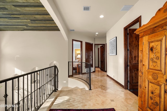 corridor with recessed lighting, visible vents, an upstairs landing, and baseboards