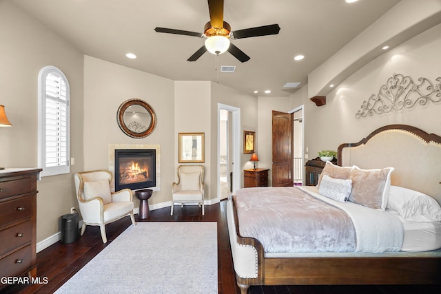 bedroom with visible vents, dark wood-type flooring, baseboards, recessed lighting, and a fireplace