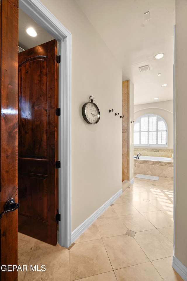 corridor with recessed lighting, light tile patterned floors, visible vents, and baseboards