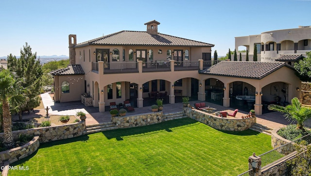 1408 Via Quijano Ln, El Paso, TX 79912 - rear view of house featuring a balcony, a patio, stucco siding, and a yard