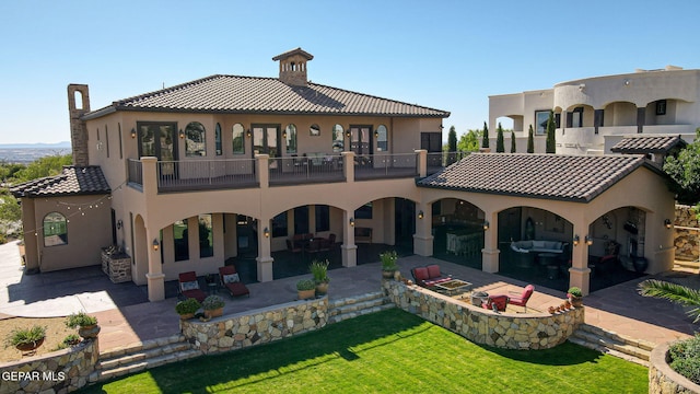 1408 Via Quijano Ln, El Paso, TX 79912 - rear view of house with a balcony, a patio area, stucco siding, and a lawn
