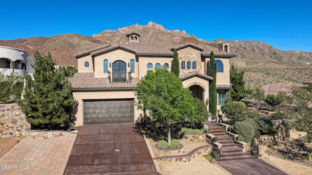 1408 Via Quijano Ln, El Paso, TX 79912 - mediterranean / spanish house with stucco siding, concrete driveway, a tiled roof, a garage, and a mountain view