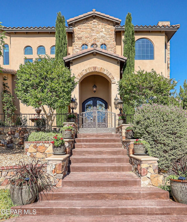 1408 Via Quijano Ln, El Paso, TX 79912 - view of exterior entry featuring stucco siding, french doors, and a tile roof