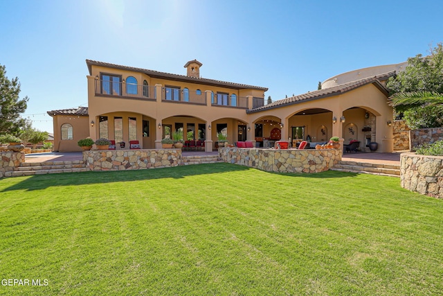 1408 Via Quijano Ln, El Paso, TX 79912 - back of property featuring stucco siding, a yard, a balcony, and a patio area