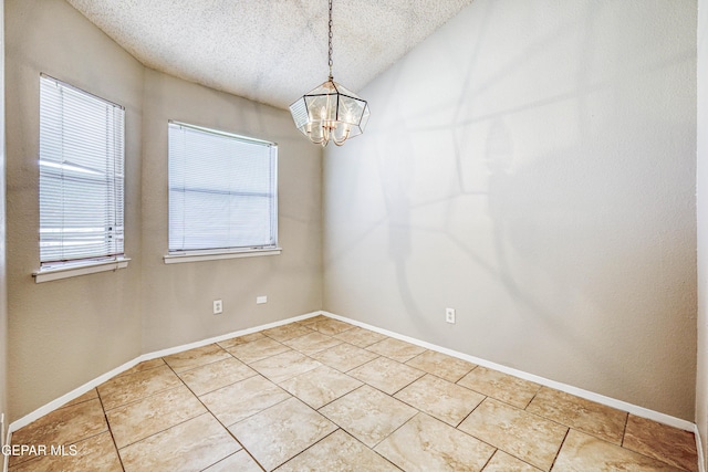 unfurnished room with a notable chandelier, light tile patterned floors, baseboards, and a textured ceiling