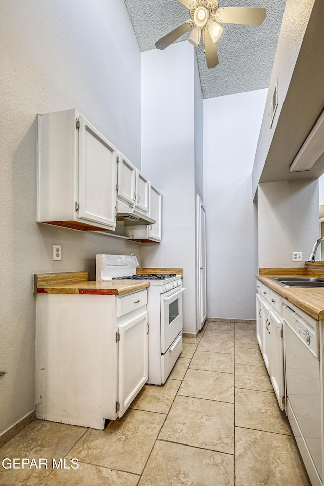 kitchen with a ceiling fan, a sink, a textured ceiling, white cabinetry, and white appliances