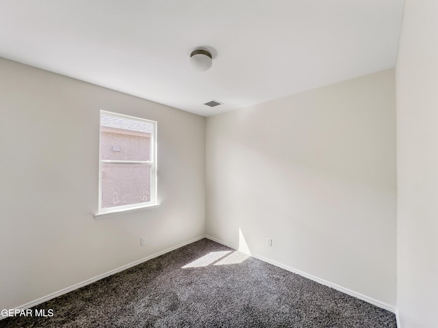 empty room with carpet flooring, visible vents, and baseboards