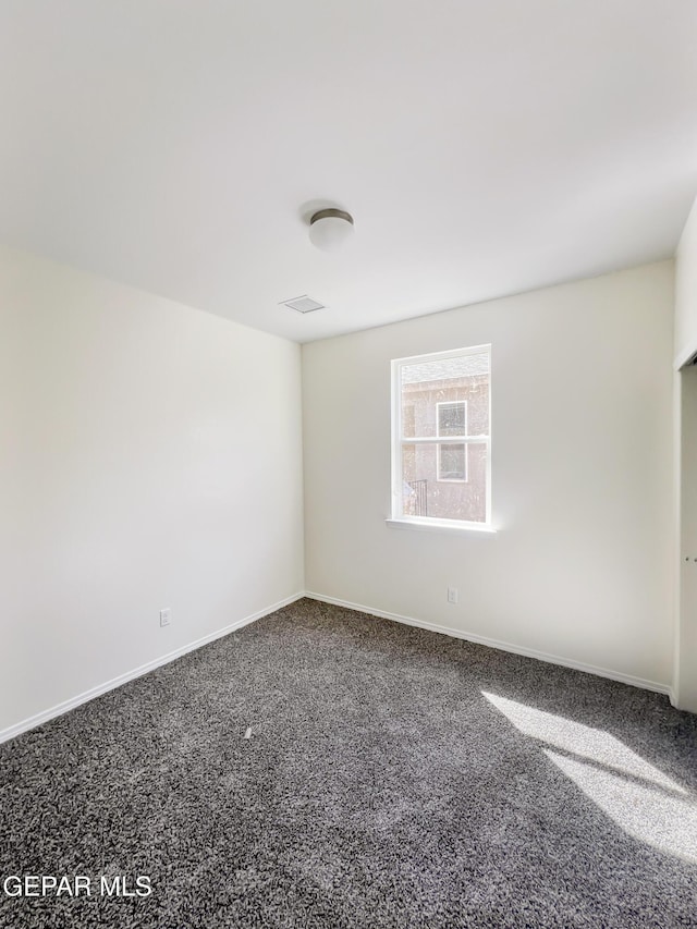 empty room with visible vents, baseboards, and carpet flooring