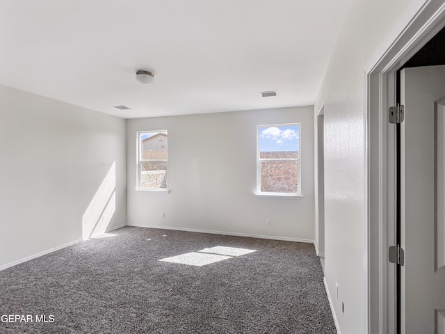 unfurnished room featuring carpet, plenty of natural light, and visible vents