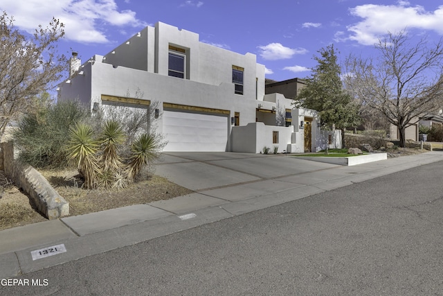 contemporary home with a garage, driveway, and stucco siding