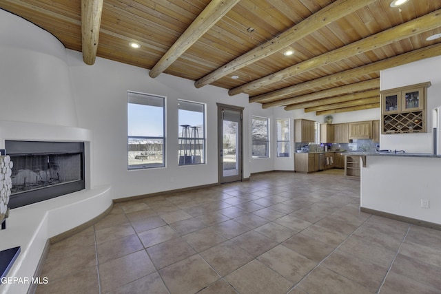 unfurnished living room with wooden ceiling, a fireplace, baseboards, and beam ceiling