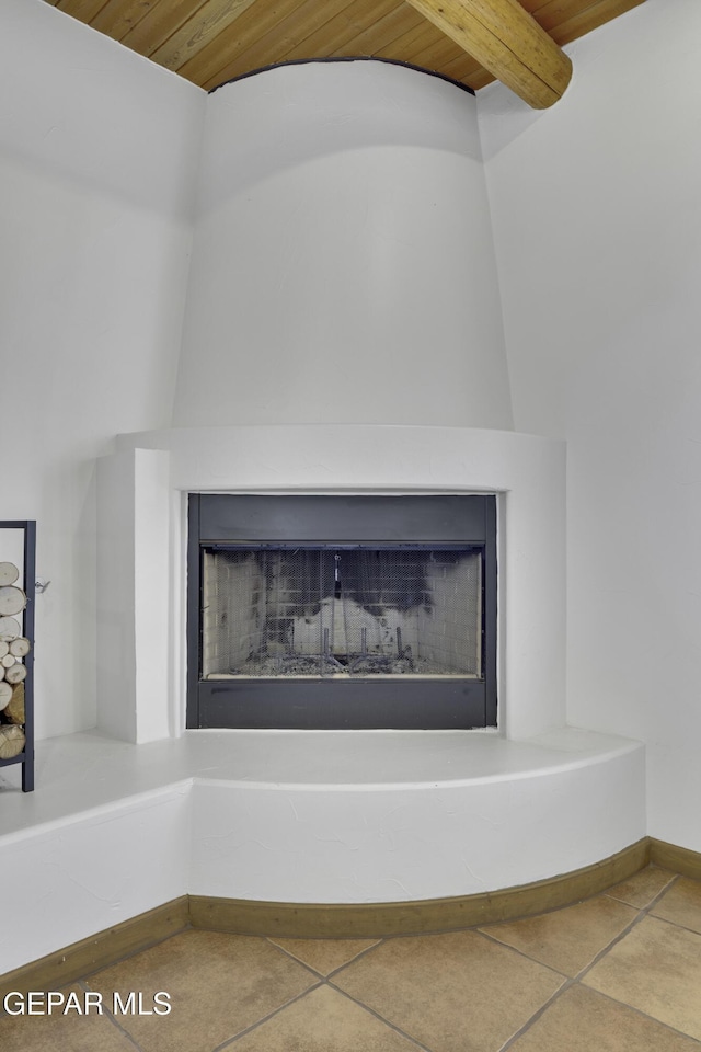 details with a fireplace with raised hearth, wooden ceiling, and baseboards