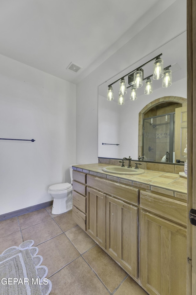 full bath featuring toilet, vanity, visible vents, a shower stall, and tile patterned floors