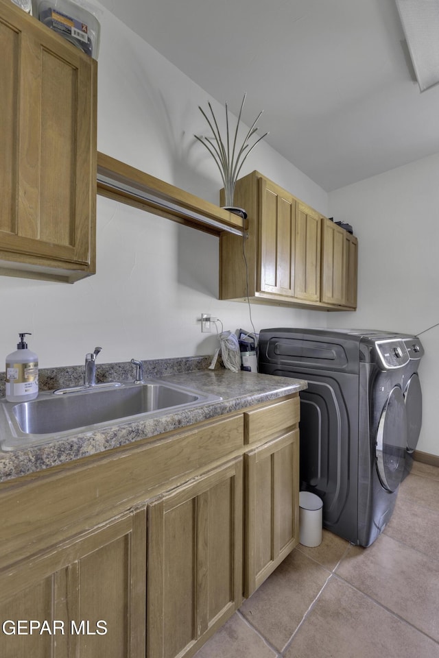 laundry room featuring light tile patterned flooring, independent washer and dryer, a sink, and cabinet space