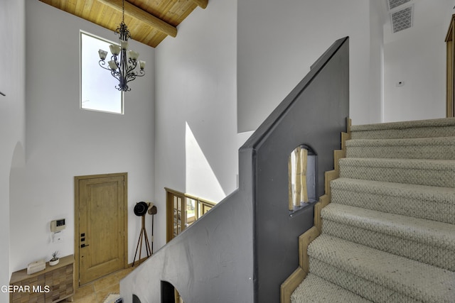 staircase with a chandelier, visible vents, high vaulted ceiling, wooden ceiling, and beamed ceiling