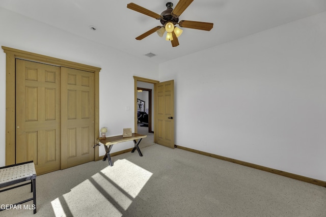 carpeted bedroom featuring a ceiling fan, visible vents, and baseboards