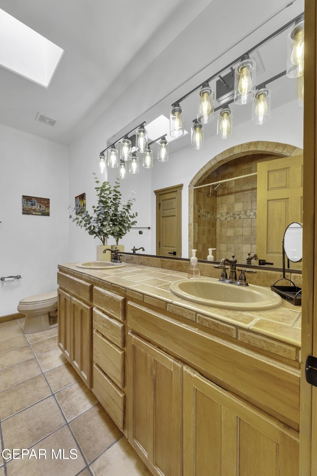 full bath with a stall shower, tile patterned flooring, a sink, and visible vents