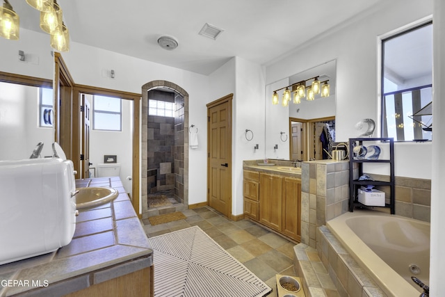 full bathroom featuring a bath, toilet, a shower stall, and vanity