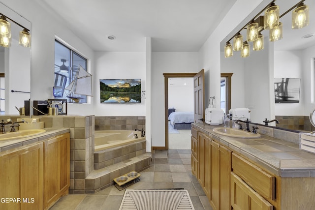 ensuite bathroom featuring two vanities, a garden tub, a sink, and ensuite bathroom