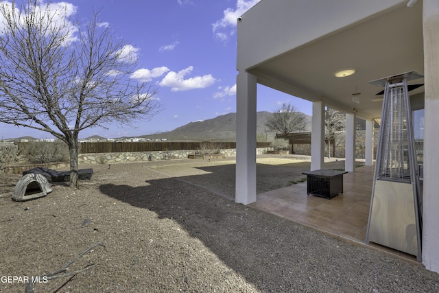 view of yard with a fenced backyard, a mountain view, and a patio