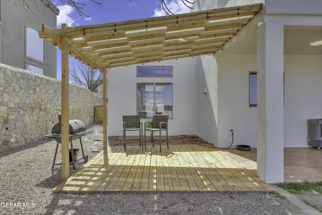 view of patio featuring outdoor dining area, grilling area, fence, a pergola, and a wooden deck