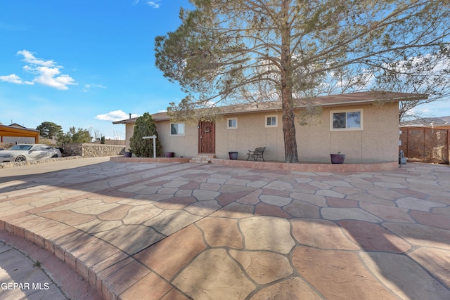 ranch-style home with stucco siding, a patio, and fence