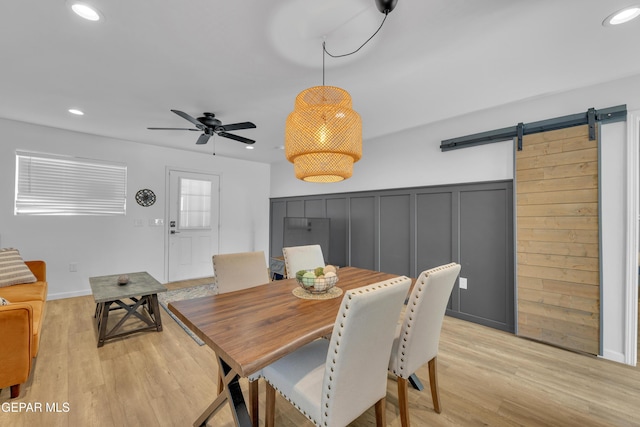 dining space with light wood-type flooring, a barn door, ceiling fan, and recessed lighting