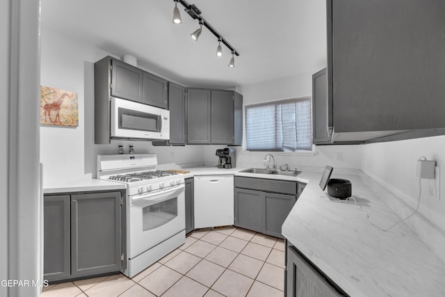 kitchen with gray cabinets, white appliances, and a sink