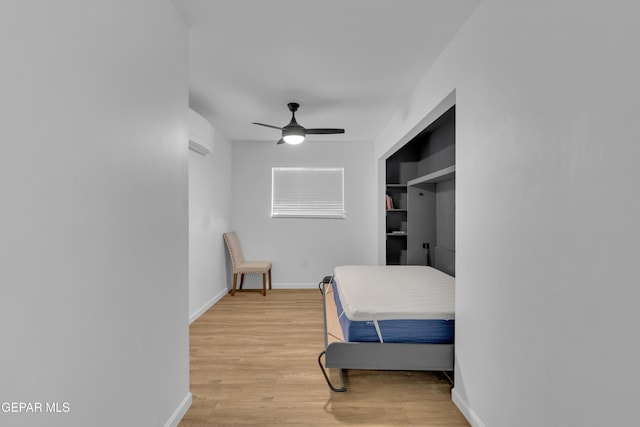 bedroom with a ceiling fan, baseboards, and light wood-type flooring