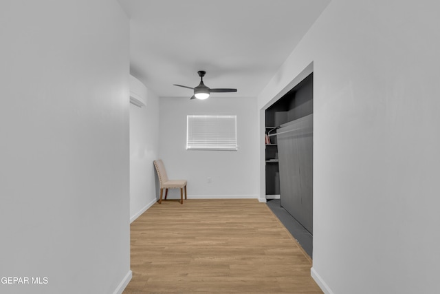 hall featuring baseboards and light wood finished floors