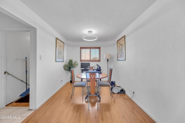 dining room featuring light wood-type flooring and baseboards