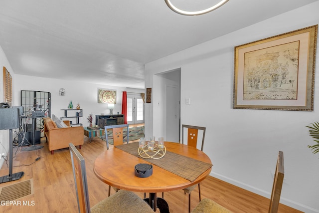 dining space with light wood finished floors and baseboards