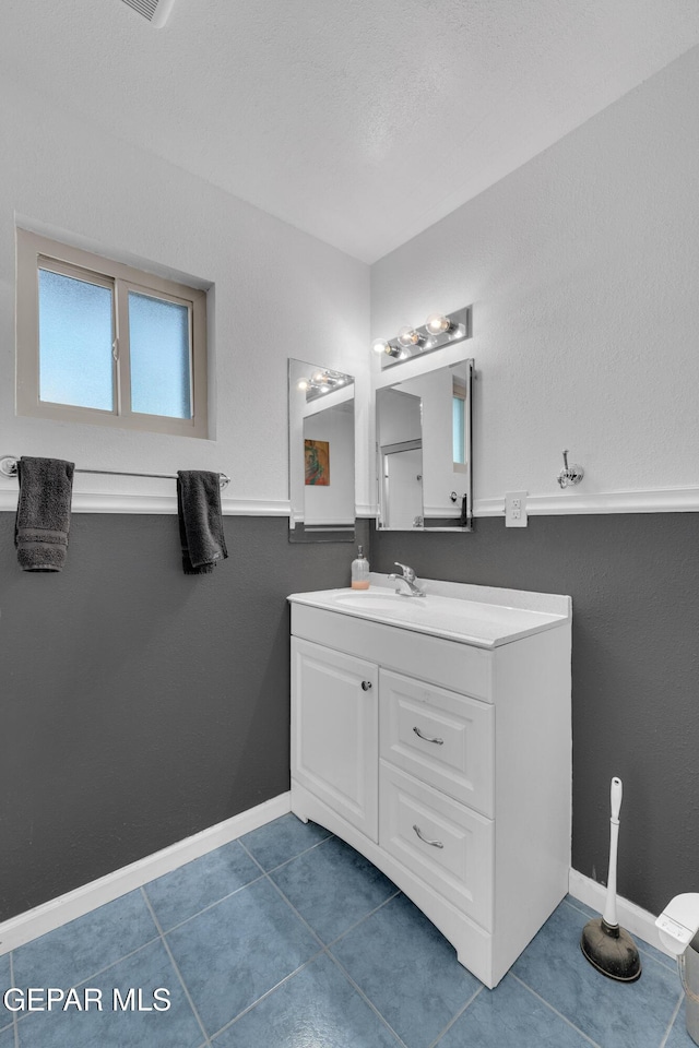 bathroom featuring vanity, tile patterned floors, and baseboards