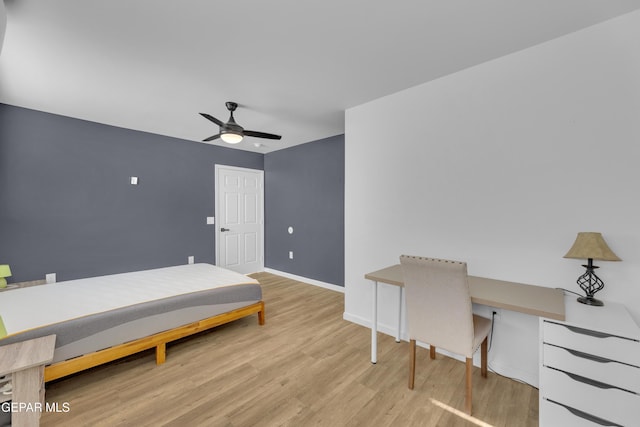 bedroom with baseboards, built in desk, wood finished floors, and a ceiling fan