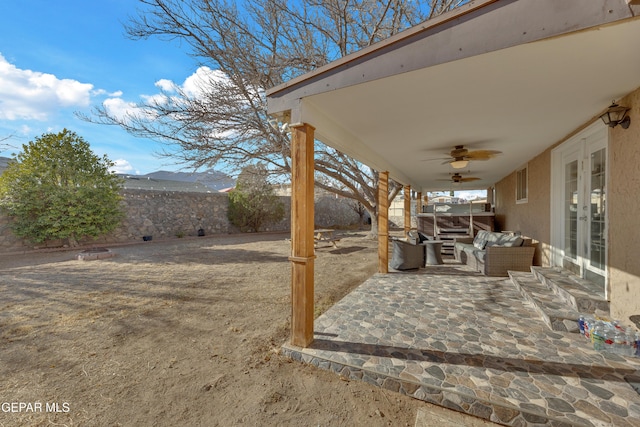 view of patio featuring an outdoor living space, french doors, a fenced backyard, and ceiling fan