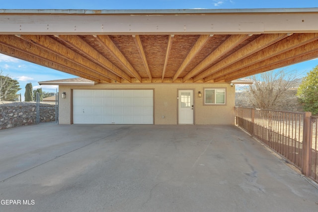 garage with a carport and fence