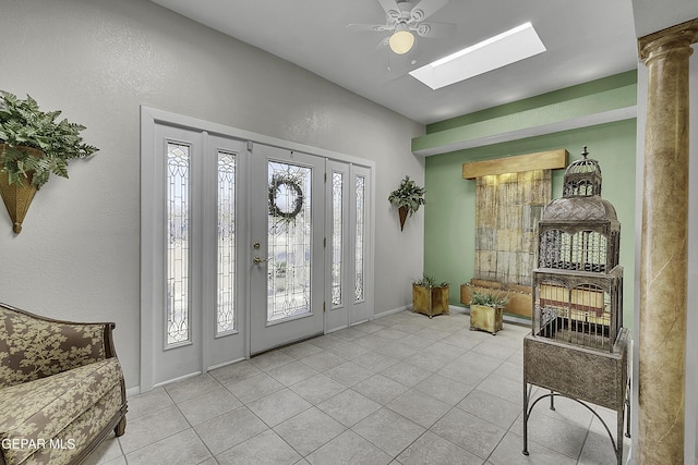 foyer entrance with a skylight, tile patterned flooring, and baseboards