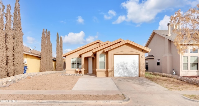 view of front of property featuring driveway, an attached garage, and stucco siding