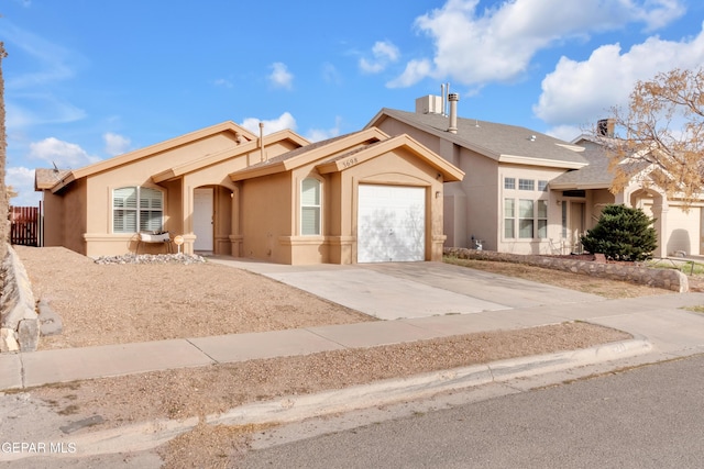 single story home with driveway, an attached garage, and stucco siding