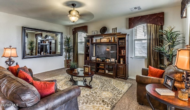 carpeted living area with visible vents, a ceiling fan, and baseboards