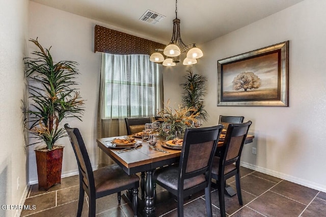 dining room with dark tile patterned floors, baseboards, visible vents, and a chandelier