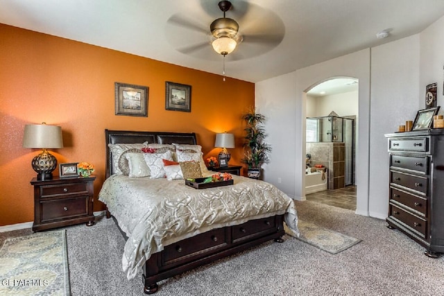 carpeted bedroom featuring arched walkways, a ceiling fan, and baseboards