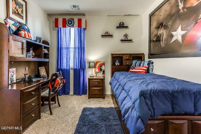 bedroom with light carpet, built in desk, and visible vents