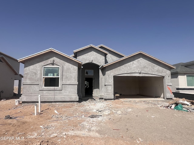 view of front facade with an attached garage and stucco siding